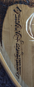Blason de bois Baratheon - zoom sur la pyrogravure calligraphiée "Ours is the fury"